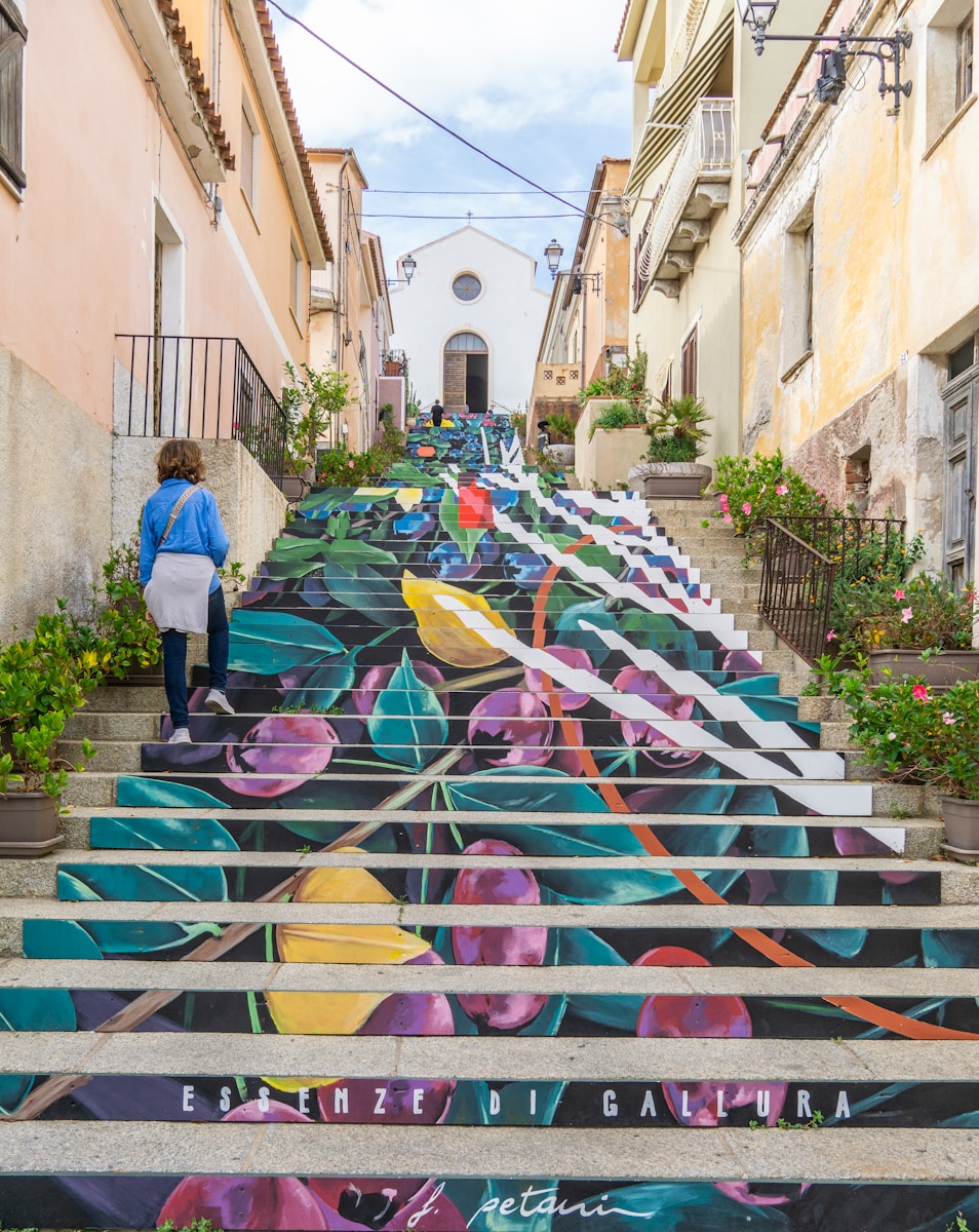 a woman walking down a set of stairs painted with flowers